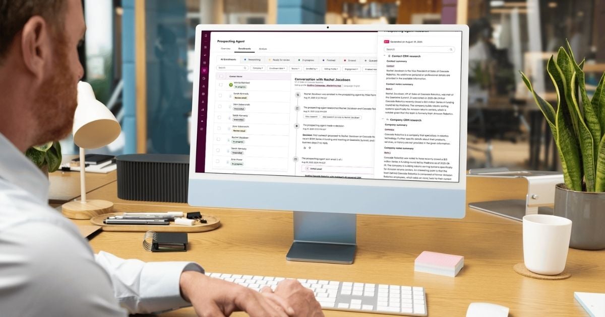 Professional working at a desktop computer using HubSpot's AI-powered prospecting agent in a modern office setting